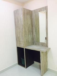 a wooden vanity with a mirror on a wall at Mega Tourist Home Palarivattom in Cochin