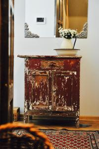 an old wooden dresser with a vase of flowers on top at Abanotubani apartment in Tbilisi City +56 photos
