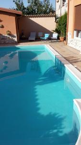 a large blue swimming pool in a yard at Villa Salvatore in San Leone