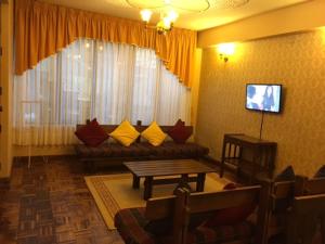 HOTEL MAISON FIORI (Plaza Colon) في كوتشابامبا: غرفة معيشة مع أريكة وطاولة