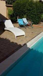 two lounge chairs and a swimming pool with two chairs and two chairssenal at Villa Salvatore in San Leone