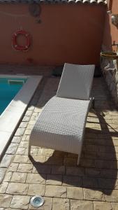 a white bench sitting next to a swimming pool at Villa Salvatore in San Leone