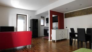 ヴェローナにあるGarden Apartmentのリビングルーム(赤いソファ、テーブル付)