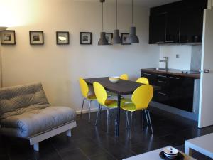 eine Küche mit einem Tisch und gelben Stühlen in der Unterkunft Residence Bidart Plage Uhabia in Bidart