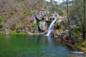 a waterfall in the middle of a pool of water at Casa São João in São João da Serra