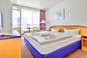 Postel nebo postele na pokoji v ubytování Strandhotel Bansiner Hof