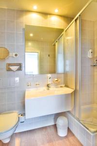 a bathroom with a sink and a shower and a toilet at Strandhotel Bansiner Hof in Bansin