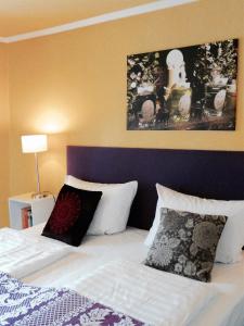 a bedroom with a bed with white sheets and pillows at Landfein Big Country House in Winterberg