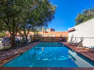a swimming pool with chairs and a fence at Boulder University Inn in Boulder