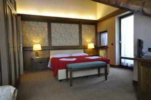ガッリオにあるHotel La Lepre Biancaのベッドルーム1室(赤毛布、ランプ2つ付)
