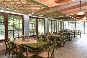 a dining room with tables and chairs and windows at Hotel Thüringer Wald in Ilmenau