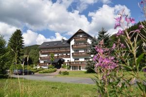 Un gran edificio de apartamentos en medio de un parque. en Hotel Thüringer Wald, en Ilmenau