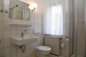 un bagno bianco con un water e un lavandino di Hotel Thüringer Wald a Ilmenau Altre 16 foto