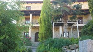 Hotel Rural San Pelayo في San Pelayo: مبنى امامه اشجار ونباتات