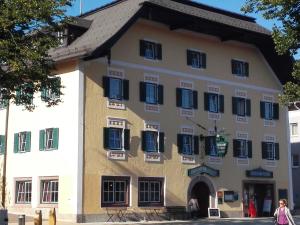 un gran edificio con persianas azules en Landgasthof Santner, en Thalgau