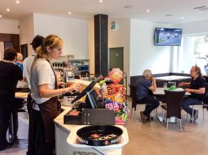 a woman preparing food at a counter in a restaurant at Hotel Rubino in Nago-Torbole