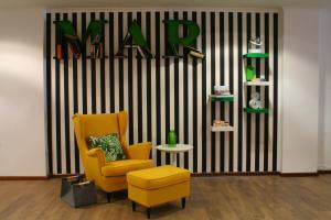 a living room with a yellow chair and a table at Vinha da Areia Beach Hotel in Vila Franca do Campo