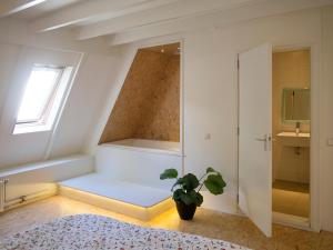 a bedroom with a tub and a potted plant at Bed & Breakfast Glimmen in Glimmen