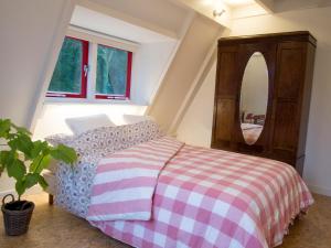 a bedroom with a bed with a dresser and a mirror at Bed & Breakfast Glimmen in Glimmen
