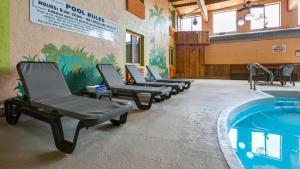 a row of chairs next to a swimming pool at Best Western La Grande Hacienda in Cherokee