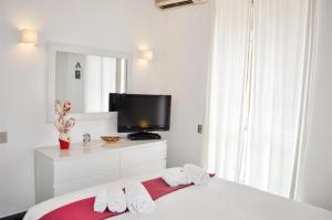 ローマにあるTestaccio Charming Apartmentの白いベッドルーム(ベッド1台、テレビ付)