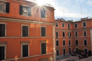 ローマにあるTestaccio Charming Apartmentの窓から日差しが差し込むオレンジ色の建物