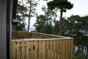 een houten hek op een veranda met bomen op de achtergrond bij Tråsåvika Camping in Viggja