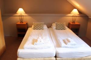 2 camas en una habitación con 2 lámparas en North Star Guesthouse Olafsvik, en Ólafsvík
