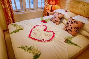 a bed with a heart decoration on it at Fulidhoo Ihaa Lodge in Fulidhoo