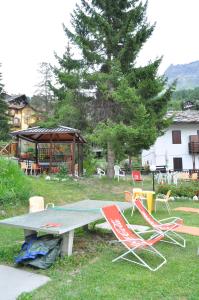a picnic table with two chairs and a gazebo at Hotel Tourist in Valtournenche