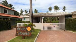 a beach house sign in front of a house at Dr Chico Beach House Peroba in Maragogi