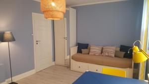 - un salon avec un canapé dans l'angle de la chambre dans l'établissement Mieszkanie Gdańsk Plaża, à Gdańsk