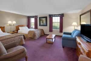 a hotel room with two beds and a flat screen tv at The Hotel Ojibway, Trademark Collection by Wyndham in Sault Ste. Marie