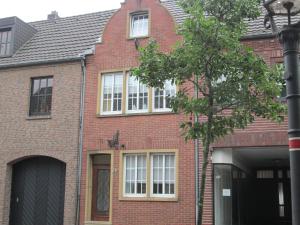 Casa de ladrillo rojo con ventanas blancas y luz de la calle en Pension Haus Waldfeucht en Waldfeucht