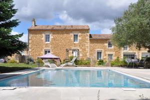 an outdoor swimming pool in front of a building at Clos San Gianni in Pujols-sur-Ciron