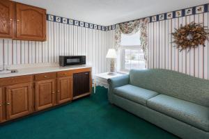 a living room with a couch and a microwave at The Hotel Ojibway, Trademark Collection by Wyndham in Sault Ste. Marie