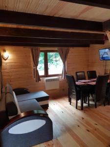 a living room with a table and chairs in a room at Domek pod śnieżką 1 in Karpacz