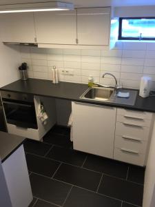 a kitchen with white cabinets and a sink at Ubak Guesthouse in Reykjavík