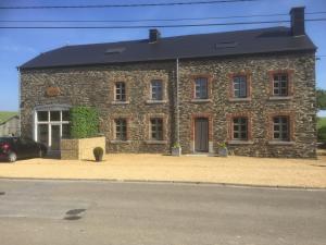 a stone building with a car parked in front of it at Le gîte de la vieille église in Tenneville