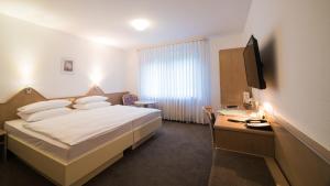 a hotel room with a bed and a desk at Hotel am Wasen in Freiberg am Neckar