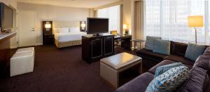 a hotel room with a couch and a bed and a television at Hyatt Regency New Orleans in New Orleans