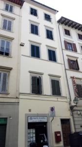 un alto edificio bianco con finestre su una strada di Studio Florence 65 a Firenze