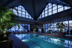 a large swimming pool in a building with windows at Park Hyatt Tokyo in Tokyo