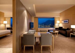 una camera d'albergo con tavolo da pranzo e soggiorno di Hyatt Regency Hong Kong, Sha Tin a Hong Kong