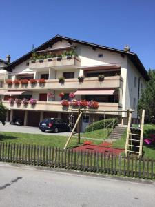 ein großes weißes Gebäude mit Blumen auf den Balkonen in der Unterkunft Apartment Lala in Interlaken