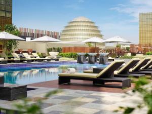 a swimming pool with lounge chairs and umbrellas at Hyatt Regency Manila City of Dreams in Manila