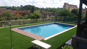 a swimming pool in a yard with green grass at Hotel La Pace in Asciano