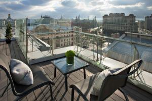 
a patio area with chairs, tables and umbrellas at Ararat Park Hyatt Moscow in Moscow
