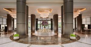 a lobby with a fountain in the middle of a building at Grand Hyatt Taipei in Taipei