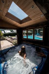 Eine Frau ist in einem Whirlpool in einem Haus in der Unterkunft Espace Pyrenees Loisirs in Argelès-Gazost